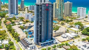A high-rise building with a modern design, surrounded by other high-rise buildings and a coastal view. - Surfers Paradise 2-Bed Near Beach with Pool & Gym (Surfers Paradise)