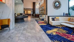 A modern lobby with marble flooring, a reception desk, seating areas, and a large mirror on the wall. - Surfers Paradise 2-Bed Near Beach with Pool & Gym (Surfers Paradise)