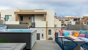 A rooftop terrace with a hot tub, outdoor seating, and a view of neighboring buildings. - CORAL CACTUS RETREAT- *DOG-FRIENDLY* Private oversized hot tub and ping pong! (Washington)
