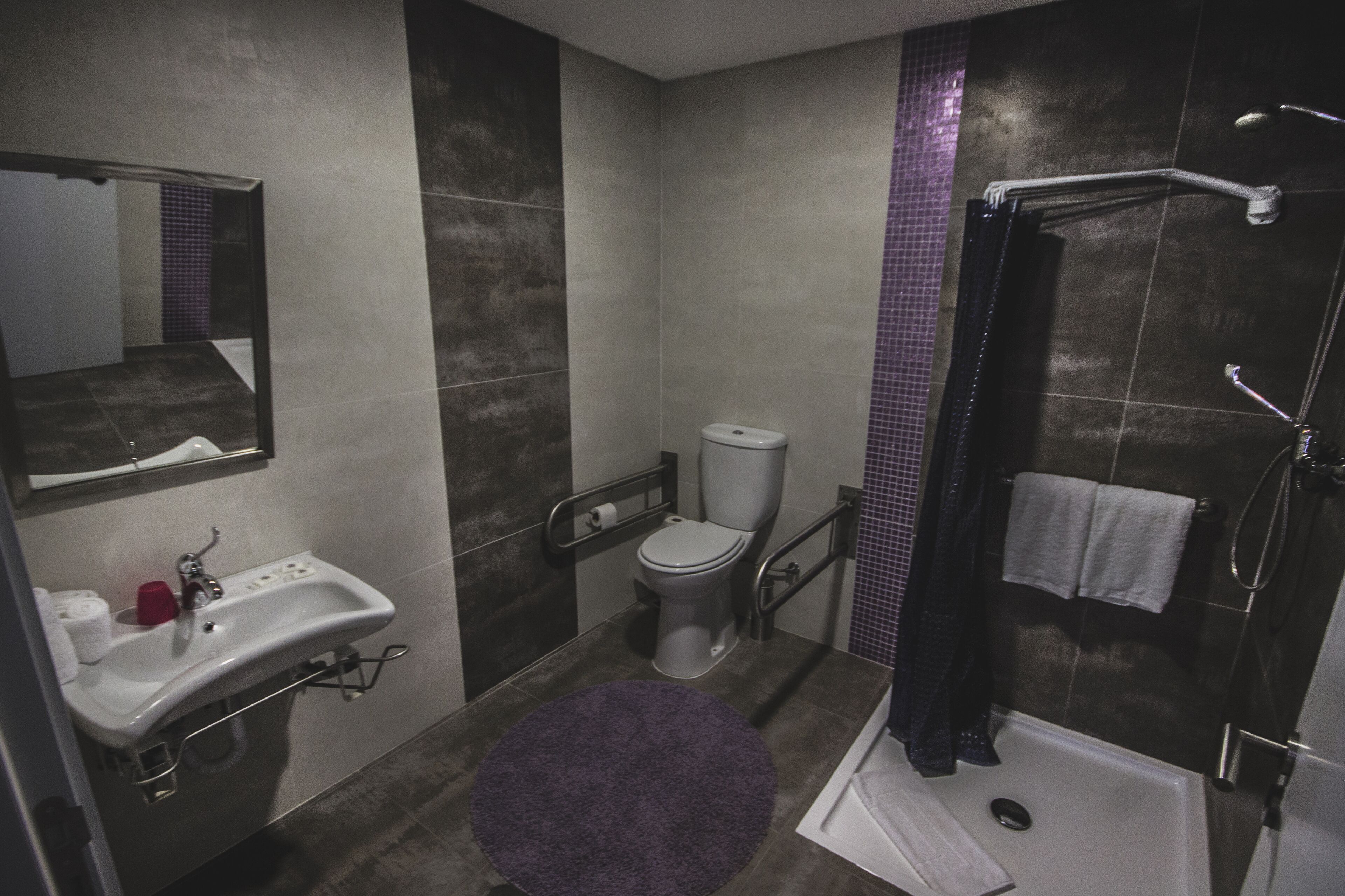 A modern bathroom with a sink, toilet, and walk-in shower.