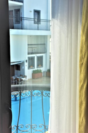 Blick auf einen Balkon mit Pool, Essbereich und ein Gebäude mit Balkonen.