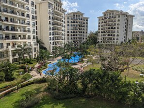 Experience serene relaxation in a tranquil pool area surrounded by lush greenery and palm trees.