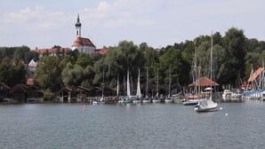 Satamassa on veneitä, kirkossa on torni ja taloissa on punaiset katot.