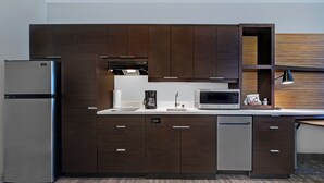 Una cocina moderna con armarios de madera oscura, electrodomésticos de acero inoxidable y un microondas integrado.