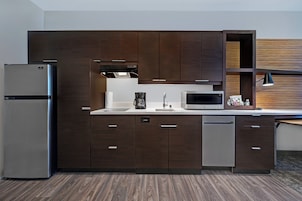 Una cocina moderna con armarios de madera oscura, electrodomésticos de acero inoxidable y un microondas integrado.