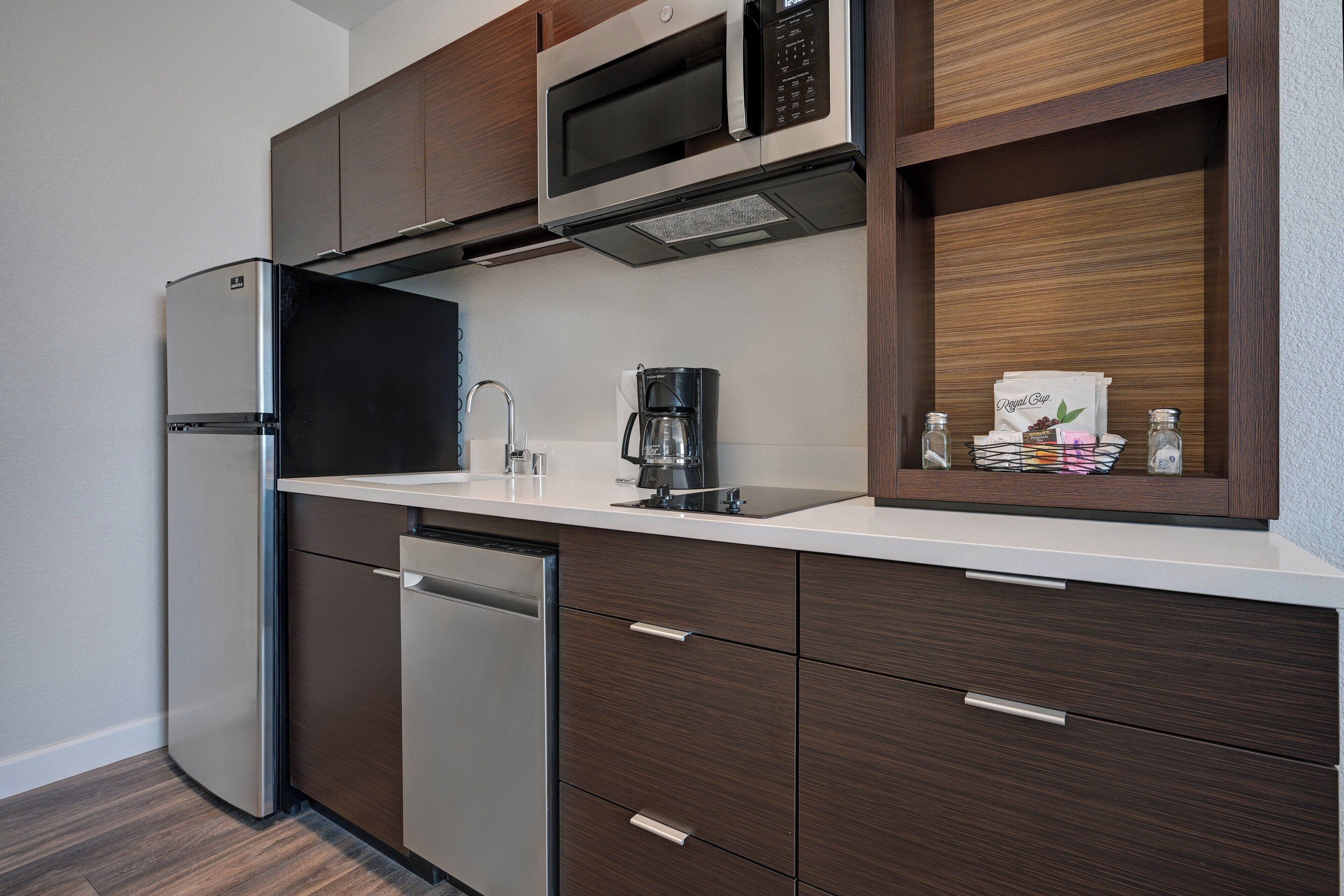 A modern kitchen with stainless steel appliances, wooden cabinets, and a built-in coffee maker.