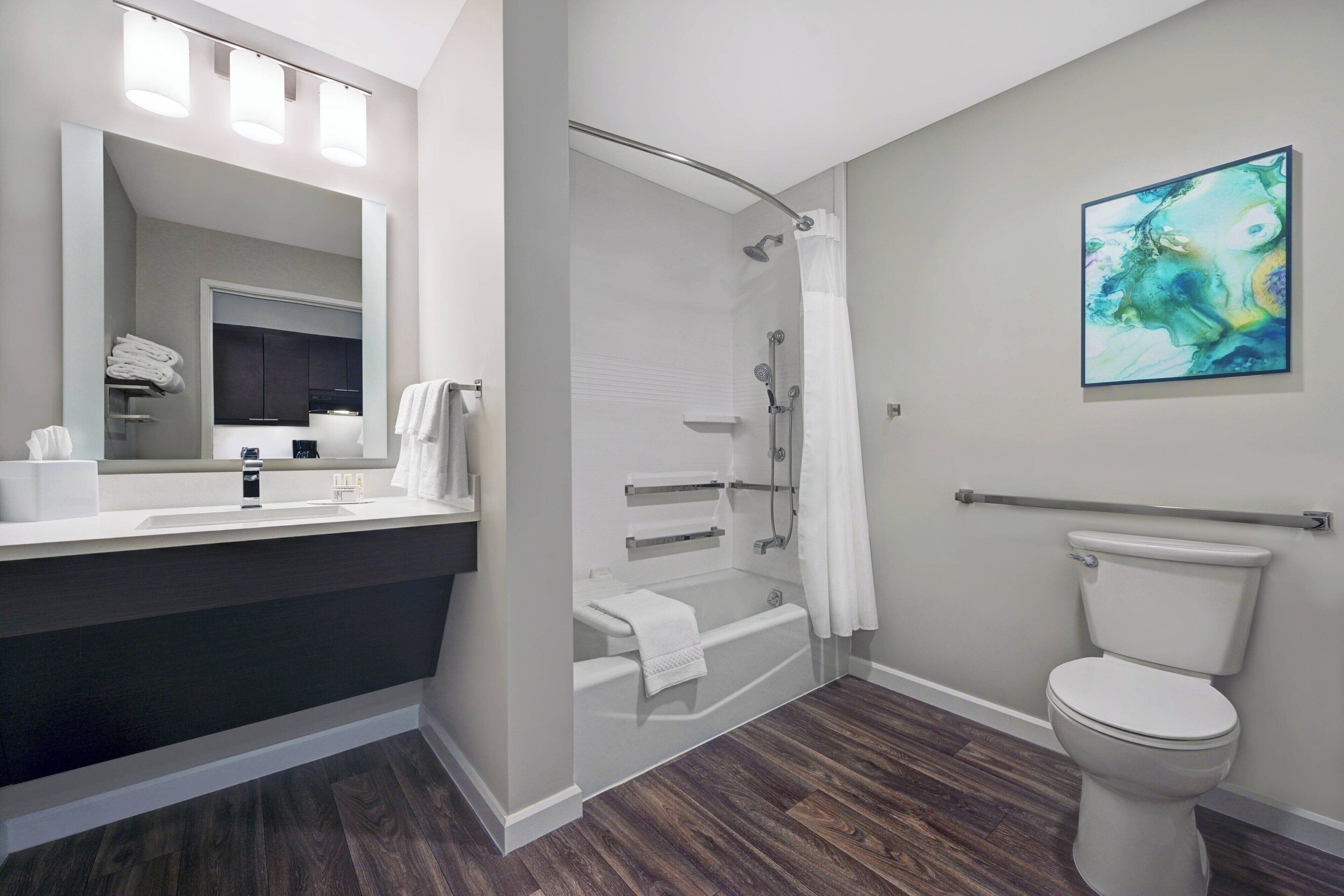 A modern bathroom with a shower, toilet, and sink.