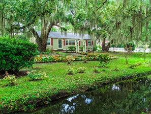 A house with a garden and a pond.