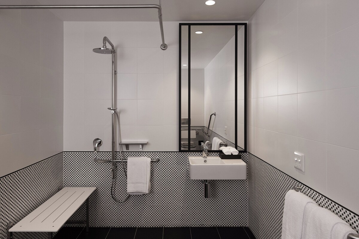 Un baño moderno con ducha, lavabo y banco.