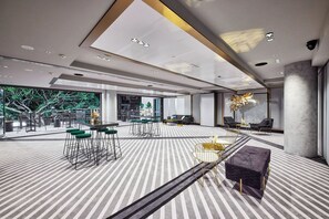 Un interior moderno con suelo a rayas, una zona de bar con taburetes y diferentes distribuciones de asientos.