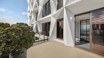 A modern building with geometric facade, large windows, and a balcony area.