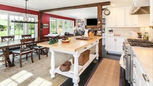 A spacious kitchen with a central island, white cabinetry, and a dining area with wooden chairs and a table. - Chatham Calling... Close to Town & Bocce (Chatham)