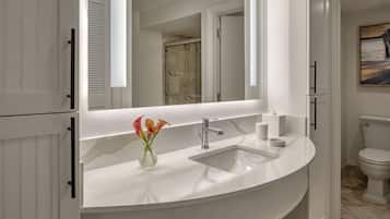 A modern bathroom with a white vanity, a large mirror, and a toilet.