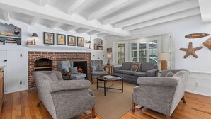 A living room with a fireplace, grey upholstered furniture, and a white ceiling.