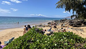 A beach with clear skies, rocky terrain, and a few people. - Totally Renovated Maui paradise condo steps away from the beaches of South Kihei (Kihei)