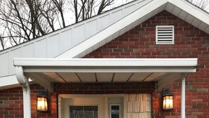 A brick house with a white door, number 3025, and two wall-mounted lanterns. - Beautiful Skinner Cottage overlooking the lake (Albion)