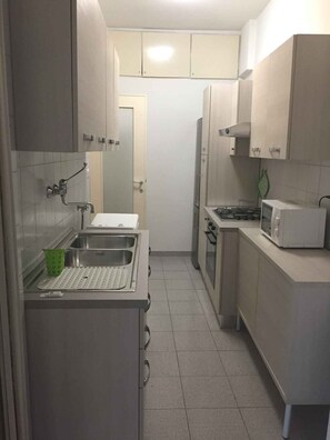 Apartamento, 2 quartos | Cozinha privada | Geladeira grande, micro-ondas, fogão, cooktop