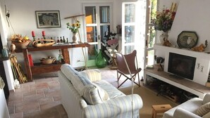 A cozy living room with a striped sofa, a wooden coffee table, and a television. - Vista Portofino (Rapallo)