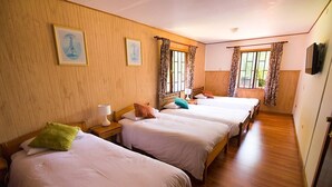 A hotel room with three single beds, wooden flooring, and a large window with curtains. - Cabañas Terrazas del Lago (Puerto Varas)