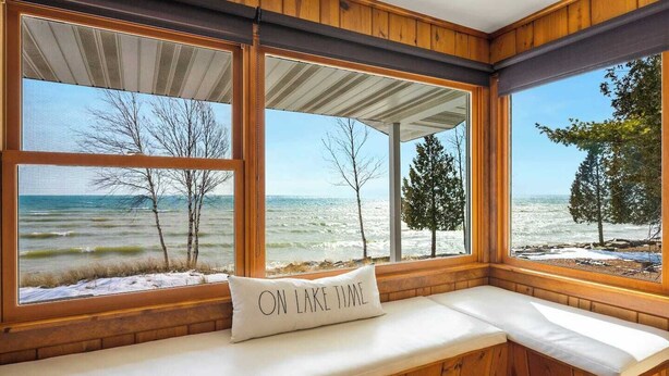 A cabin with large windows overlooking a snowy landscape and a view of the ocean. - Waterfront property + Beach + Internet (Sturgeon Bay)