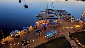 A marina with boats docked, a lighthouse, and outdoor seating with umbrellas. - The Tuna Blue Inn and Restaurant (Hubbards)