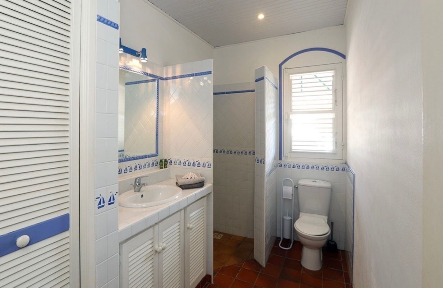 A compact bathroom with a sink, mirror, and toilet.