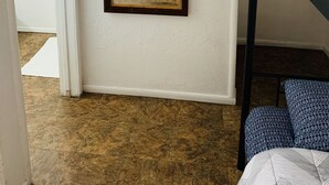 Una habitación con literas, un espejo y una puerta que da a otra habitación.