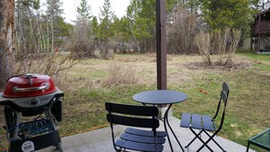 An outdoor patio with a grill, a table, and two chairs. - JHRL - Aspens Juniper 114, perfect for a couple or single vacationers (Wilson)