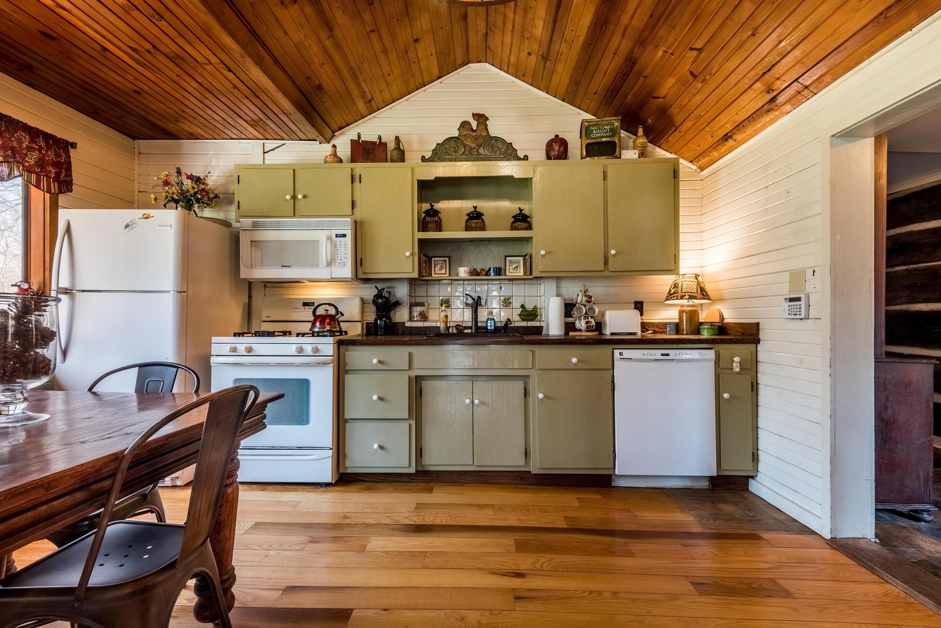 A kitchen with wooden cabinets, a refrigerator, microwave, stove, and dishwasher.