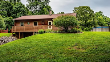 Surrounded by lush greenery, this cabin offers a tranquil retreat with a well-maintained lawn and a small pond.