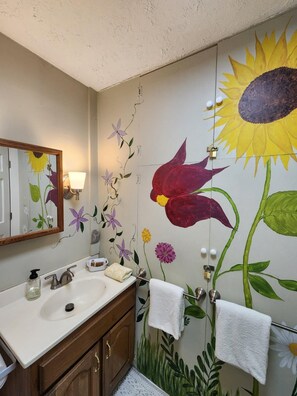 A bathroom with a large floral mural, a sink with a mirror, and a towel rack. - Romantic Creekside Cottage w/ Hot Tub | 2 Miles to Nashville (Nashville)