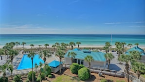 A resort with a swimming pool, beach view, and palm trees. - Oceanfront Dunes B406 + Free Seasonal Beach Loungers (Panama City)