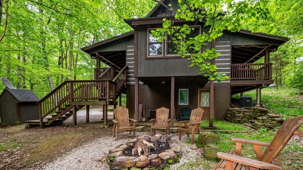 A cabin with a deck, outdoor seating, and a fire pit. - Romantic Log Cabin w/ Hot Tub, Jetted Tub & Wood Stove (Nashville)