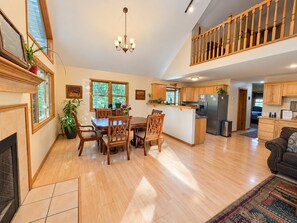 A spacious kitchen with wooden cabinets, a dining area with a table and chairs, and a living room with a sofa.