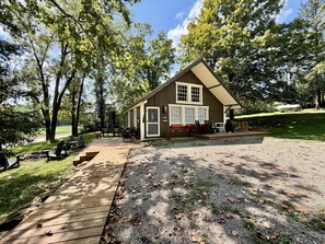 A cabin with a deck, outdoor seating, and a gravel area. - 1 King Bed Loft + Bd , 1BA (Nashville)