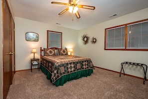 A bedroom with a bed, two bedside lamps, a ceiling fan, a window with blinds, and a door. - Private Country Resort | Pool, Hot Tub & 5 Wooded Acres (Morgantown)