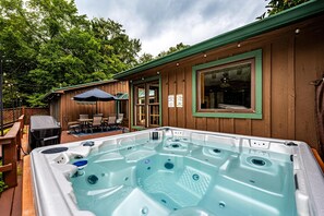 A hot tub on a wooden deck with a covered patio area and a view of a forested area. - Private Country Resort | Pool, Hot Tub & 5 Wooded Acres (Morgantown)