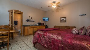 A bedroom with a bed, a desk, a chair, a television, and a ceiling fan. - Cowgirl Guest Suite | Near Trails, Events & Music Barn 1BR, 1BA (Nashville)