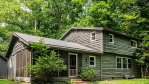A rustic wooden house with a porch, a small front yard, and a pathway leading to the entrance. - 85-Acre Family Cabin | Sleeps 12, Hot Tub & Near Nashville 4BR, 2 BA (Nashville)