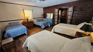 A room with two beds, wooden walls, a dresser, a mirror, and a chair. - 85-Acre Family Cabin | Sleeps 12, Hot Tub & Near Nashville 4BR, 2 BA (Nashville)