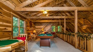 A wooden interior with a pool table, a sofa, and a ceiling fan. - Private 10-Acre Log Cabin | Hot Tub & Near State Park 2BR, 2.5 BA (Nashville)