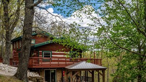A cabin with a wooden exterior, a balcony, and a covered outdoor seating area. - Mountain View Log Cabin | Hot Tub, 3 Kings & Game Room 3BR, 3BA (Nashville)
