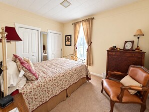 A bedroom with a bed, a dresser, a chair, and a lamp. - Farmhouse Retreat 2 Miles to Nashville | Hot Tub 3BR, 2BA (Nashville)