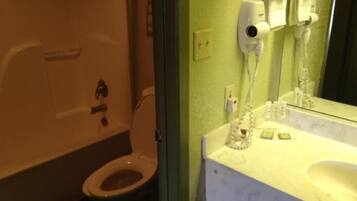 A bathroom with a toilet, a sink, and a mirror.