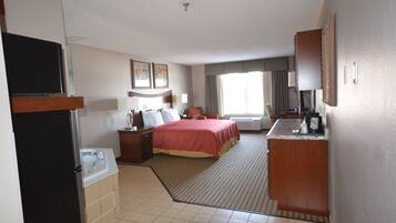 A hotel room with a bed, a desk, a sink, and a television.