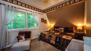 A bedroom with a large bed, a chair, a desk, and a window with curtains. - Cabin w/ Pond, Hot Tub & Pool Table | Family-Friendly Retreat 3BR, 2BA (Nashville)