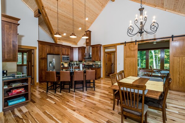 A spacious kitchen with wooden cabinets, a central island, and pendant lighting.
