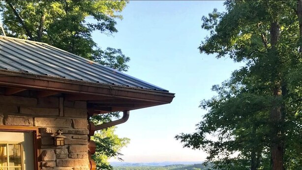 A wooden deck with Adirondack chairs and a hot tub, overlooking a forested valley. - Secluded 100-Acre Cabin | Hot Tub, Views & Wildlife 3BR, 1.5BA (Nashville)