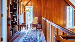 A wooden interior with a high ceiling, a staircase, a bookshelf, and a patterned rug. - Ridgetop Cabin w/ Hot Tub & Sunset Views | 2 Min to Nashville 2BR+, 2 BA (Nashville)