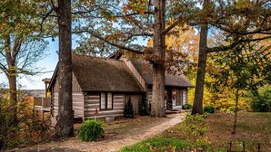 A rustic log cabin with a covered porch, surrounded by trees and a brick pathway. - Ridgetop Cabin w/ Hot Tub & Sunset Views | 2 Min to Nashville 2BR+, 2 BA (Nashville)